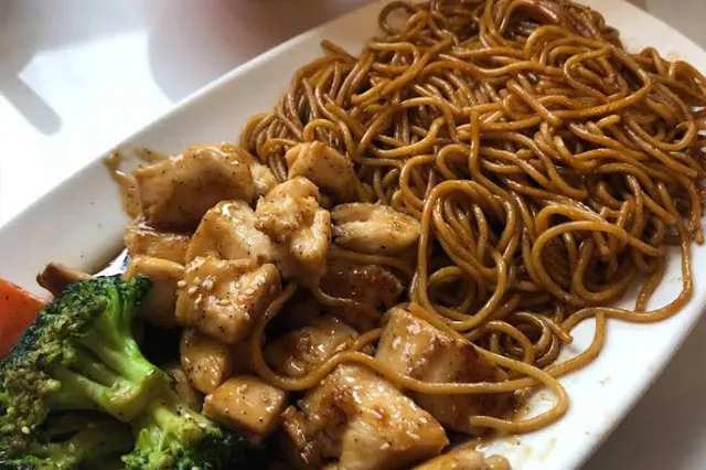 Stir-fried noodles with chicken and broccoli.
