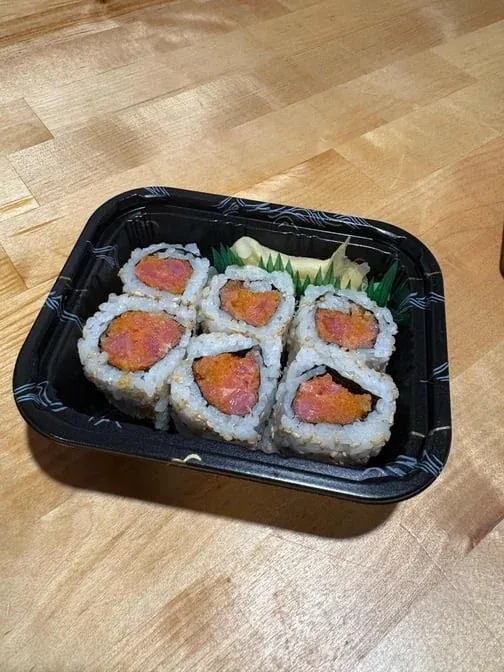 A tray of spicy tuna maki rolls.
